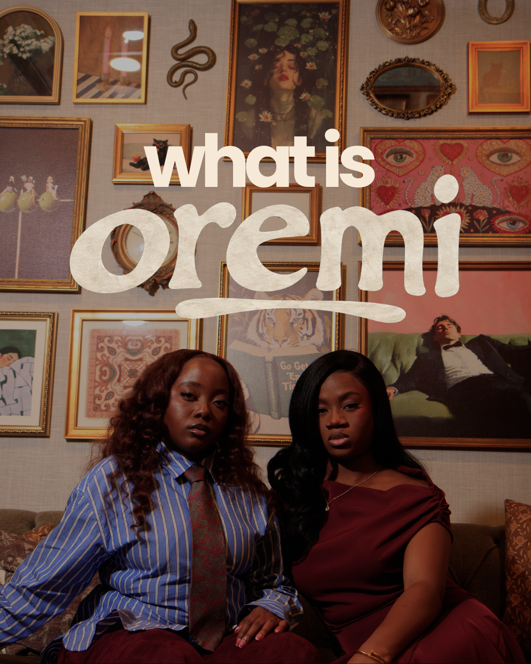 “what is oremi” cover design — two women seated on an upholstered couch in front of a gallery wall of framed art and mirrors